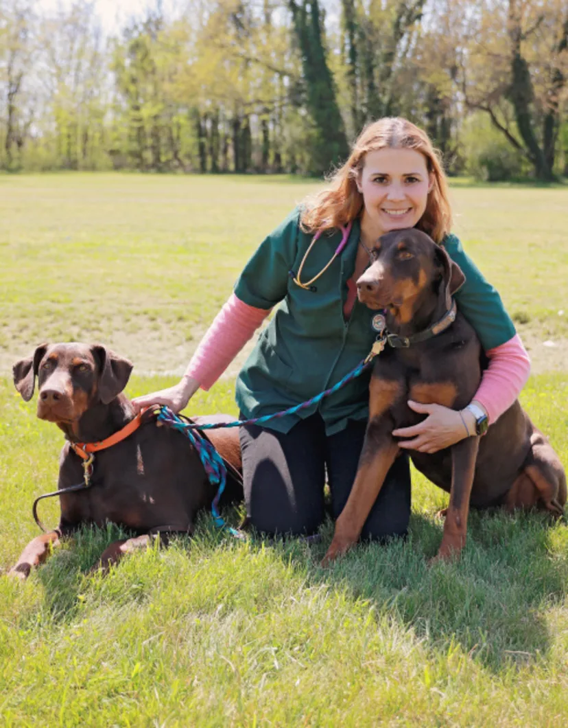 Dr. Adrienne B. Foster's stafff photo with her dobberman pincher next to her in the picture for Ferry Farm Animal Clinic photo op. 